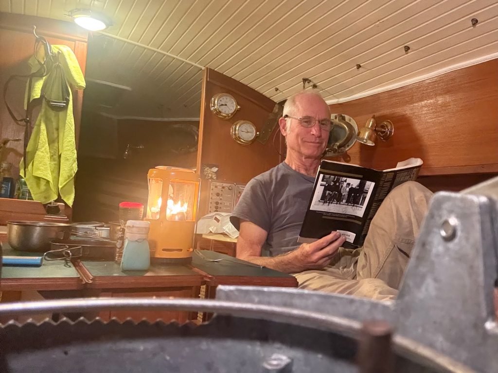 Reading Stone Alone in the cabin of Grit at anchor